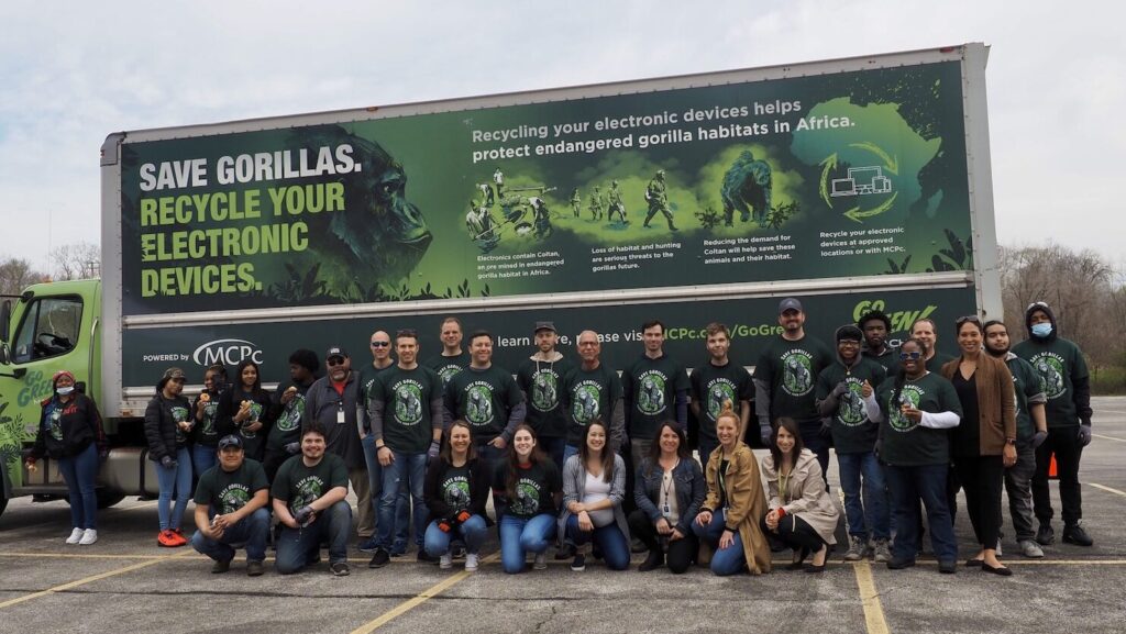 A group photo of volunteers from MCPC, Cleveland Metroparks Zoo, and Cleveland Zoological Society is taken with the Go Green Machine truck in the background.