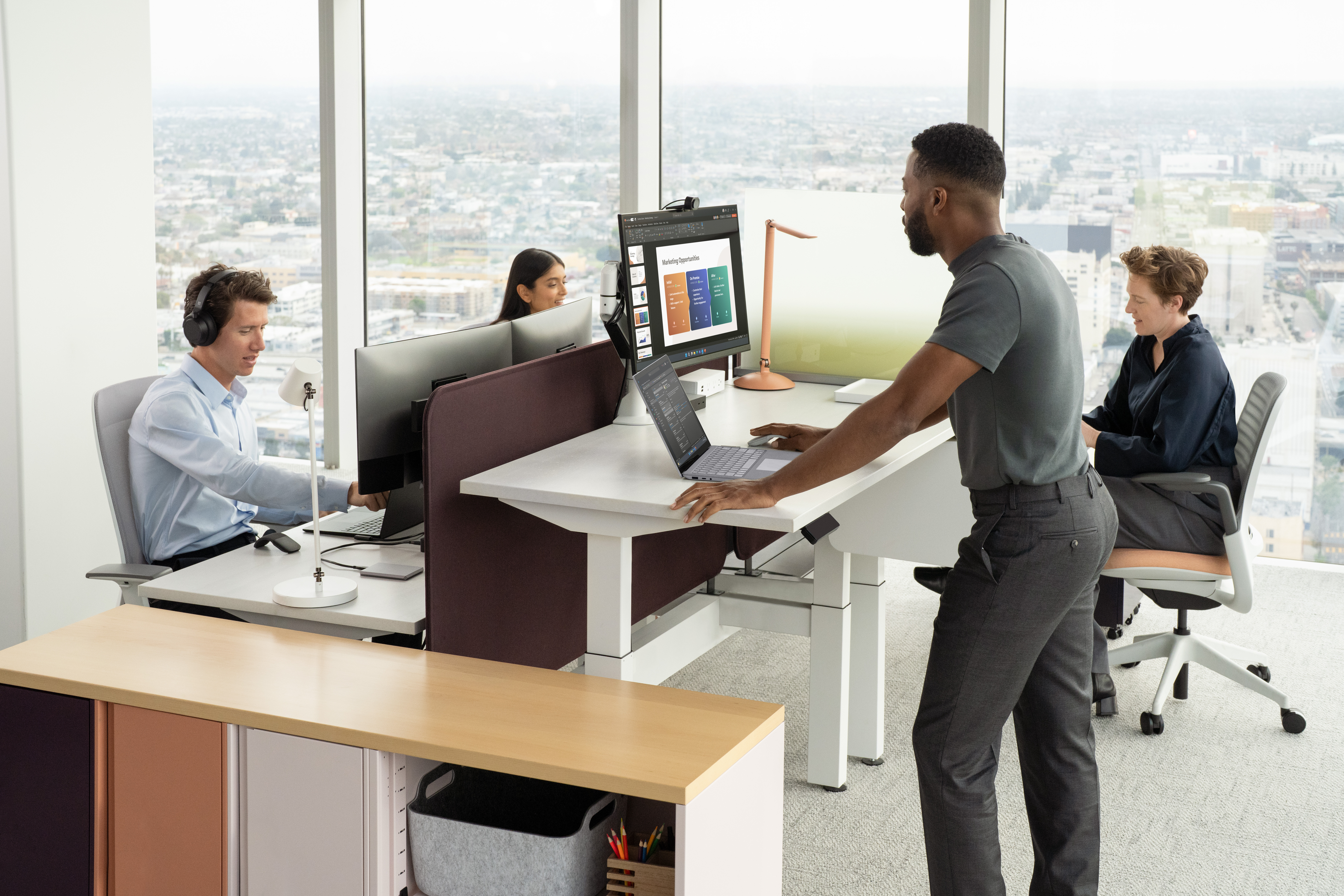 Group in modern office space using Microsoft Surface products at desks